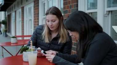 İki genç kadın sokak bir kafede yaslanın ve rahatlayın