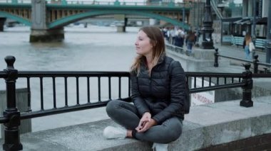 Duvarda oturan genç yirmi yaşında bir kız ve düşüncelerinde kaybetti