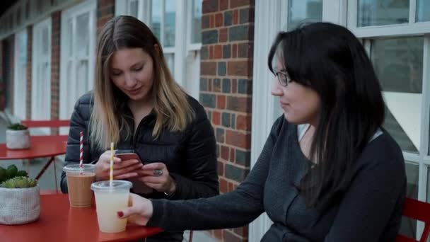 Deux jeunes femmes s'assoient dans un café de rue et se relaxent — Video