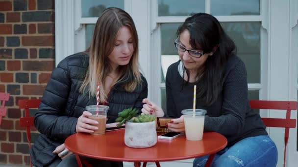 Друзья встречаются в уличном кафе — стоковое видео