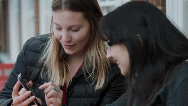 Zwei Mädchen schauen auf das Handy — Stockvideo