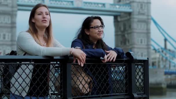 Dos mujeres jóvenes en el Tower Bridge en Londres - viaje a la ciudad — Vídeo de stock