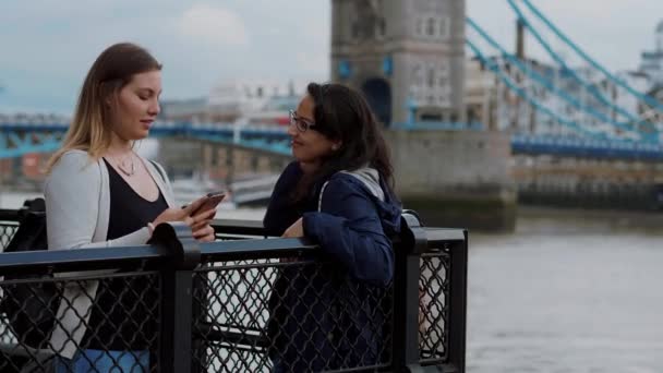 Twee jonge vrouwen in de Tower Bridge in Londen - citytrip — Stockvideo