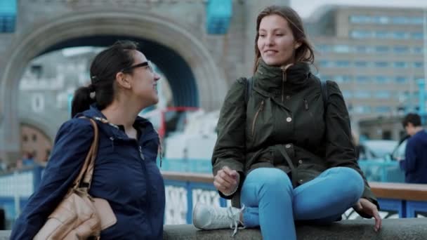 Två unga kvinnor på Tower Bridge i London - cityresa — Stockvideo