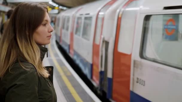 Junge Frau wartet auf die Londoner U-Bahn — Stockvideo