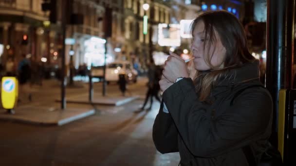 Mujer joven fuma un cigarrillo en las calles de Londres — Vídeos de Stock
