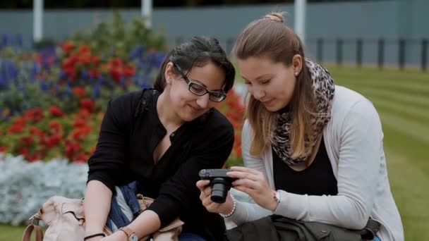 Dos chicas jóvenes se relajan en un parque — Vídeos de Stock