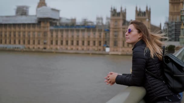 Chica rubia joven en Londres - Puente de Westminster y Casas del Parlamento — Vídeo de stock