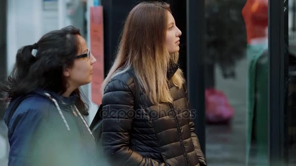 Две девушки смотрят на витрины магазинов в миле от магазинов — стоковое видео