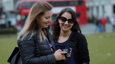 İki genç kadın kontrol fotoğraf makinesinde - Londra gezi yavaş hareket