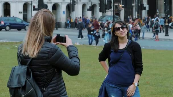 Девушка позирует для фотографии в Лондоне в замедленной съемке — стоковое видео