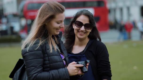 Twee jonge vrouwen check foto's op de camera - Londen sightseeing in slow motion — Stockvideo