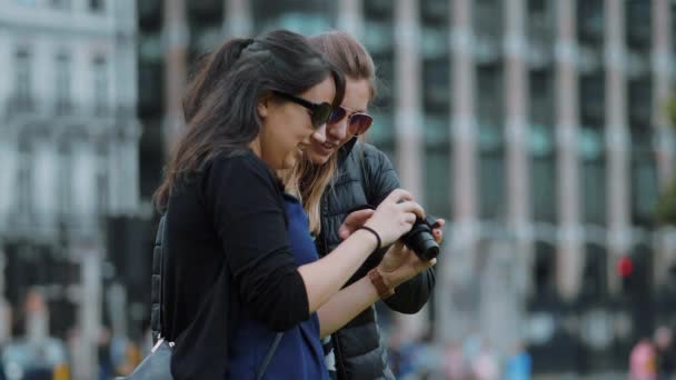 Dos mujeres jóvenes revisan fotos en la cámara - Londres turismo en cámara lenta — Vídeo de stock