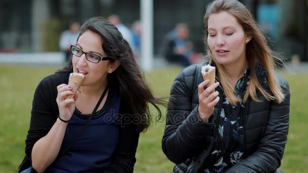 Δύο κορίτσια τρώνε παγωτό σε μια ηλιόλουστη ημέρα - αργή κίνηση — Αρχείο Βίντεο