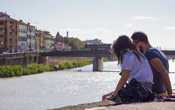 Couple in love relax at the banks of River Arno in Pisa - PISA ITALY - SEPTEMBER 13, 2017 — Stock Photo, Image