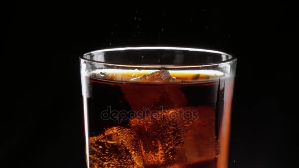 Ledové kostky plovoucí v sklenici osvěžujícího cola — Stock video