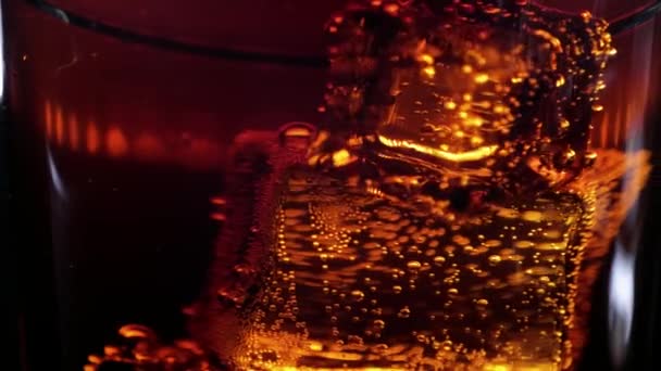 Schwebender Eiswürfel in einem Glas Cola - Limo-Drink in Zeitlupe — Stockvideo