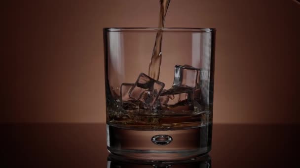 Nalévání whisky ve sklenici s ledem - krásný zpomalený záběr — Stock video
