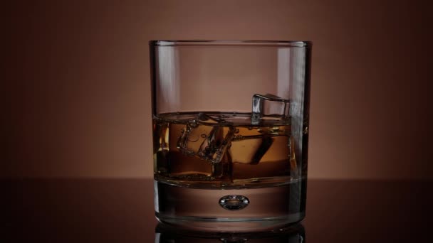Whisky s ledem - pomalý pohyb shot sklenice Whiskey — Stock video