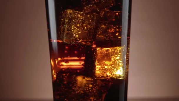Un vaso de refrescante Cola con cubitos de hielo flotantes — Vídeos de Stock