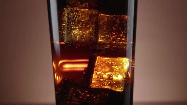 Een glas Cola verfrissend met ijsblokjes drijvende — Stockvideo