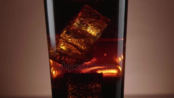 Ein Glas erfrischende Cola mit schwimmenden Eiswürfeln — Stockvideo