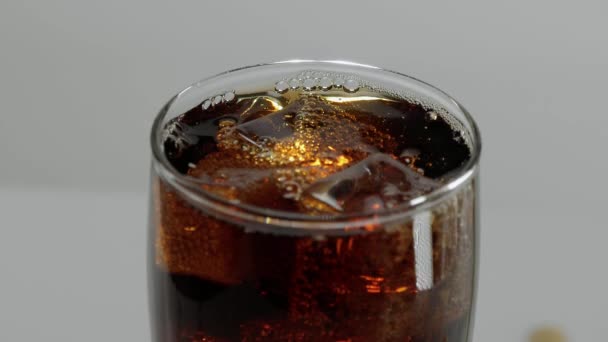 Jégkocka esik egy pohár Cola lassítva - szénsavas üdítő — Stock videók