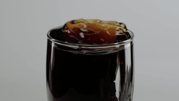 Ice cubes fall in a glass of Cola in slow motion - refreshing soda — Stock Video