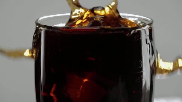 Splash ledu studená Cola - kostky ledu pádu ve sklenici sodovky — Stock video