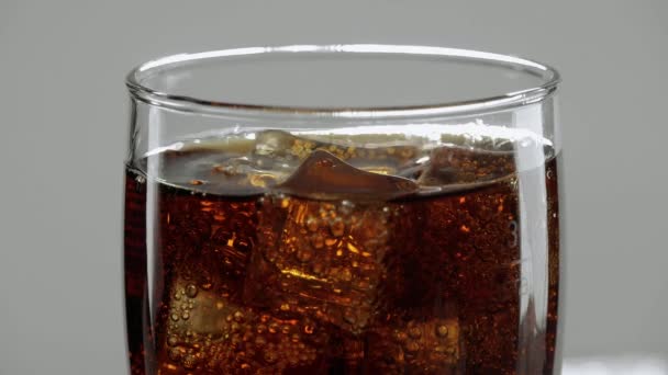 Increíble primer plano de una copa de Cola con cubitos de hielo - refresco refrescante en cámara lenta — Vídeo de stock