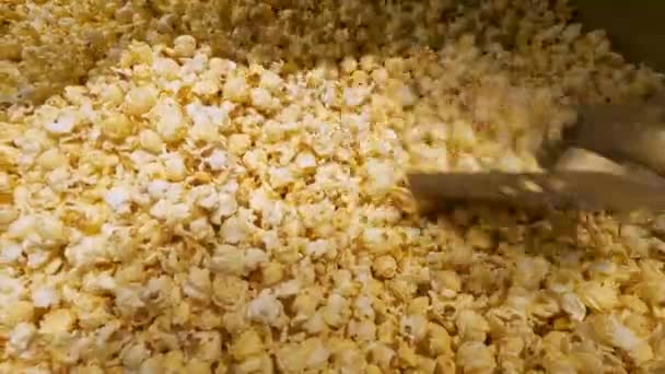 Mexendo em uma massa de pipocas torradas frescas — Vídeo de Stock