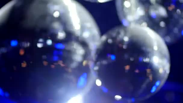 Вращающиеся зеркальные шары в клубе, отражающие синий свет - крупным планом — стоковое видео