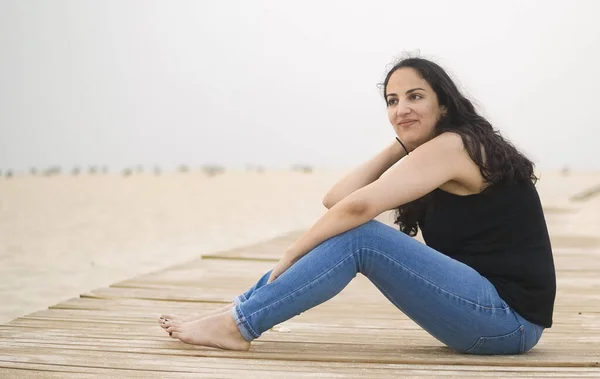 Young woman relaxes on the beach during her summer vacation — Stock Photo, Image