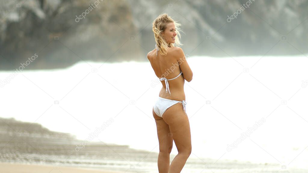Sexy girl on Adraga Beach at the Atlantic Ocean coast in Portugal