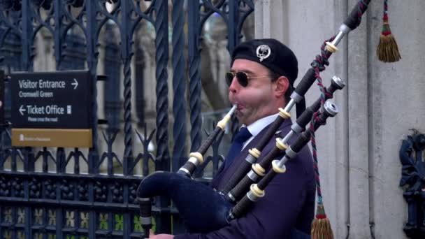 Bagpipe player in the Streets of London - LONDON, ENGLAND - 10 ДЕКАБРЯ 2019 — стоковое видео
