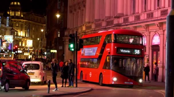 Röd buss Piccadilly Circus London på natten - London, England - 10 december 2019 — Stockvideo