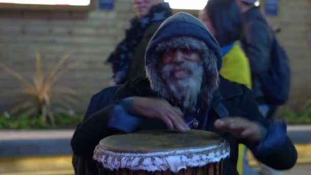 집없는 남자가 런던 레스터 광장에서 길거리 음악가로 공연하는 모습 - 영국 런던 - 2019 년 12 월 10 일 — 비디오