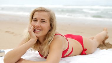 Bikinili seksi kadın okyanusun kumlu sahilinde rahatlıyor. Seyahat fotoğrafçılığı.