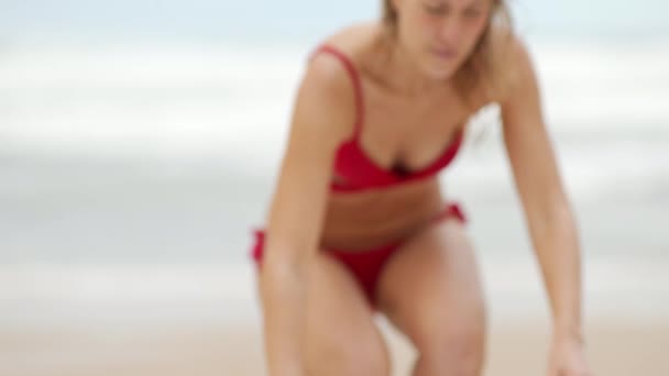 Сексуальная женщина в бикини расслабляется на песчаном пляже у океана — стоковое видео