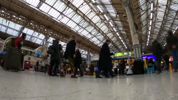 Подорожуючі на залізничному вокзалі - таймелапс застрелений - Лондон, Англія - 10 грудня 2019 року — стокове відео