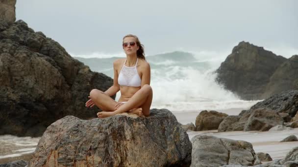 Σέξι γυναίκα κάθεται σε ένα βράχο στον Ατλαντικό Ωκεανό — Αρχείο Βίντεο