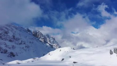 Flight over snow-capped mountains in the Swiss Alps on a winters day - aerial footage