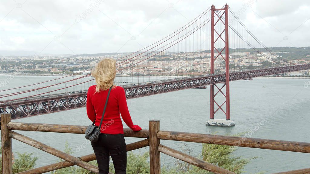 Attractive woman in Lisbon enjoys the view over Tagus River - travel photography