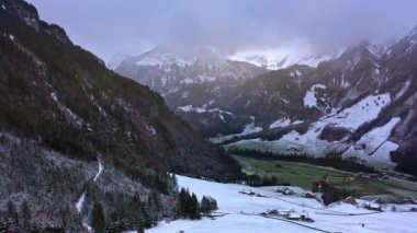 Flight over snow-capped valleys and mountains in winter - aerial footage