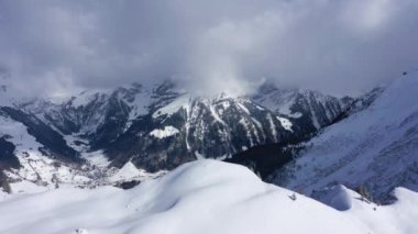Flight over snow-capped mountains in the Swiss Alps on a winters day