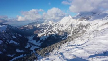 Flight over snow-capped mountains in the Swiss Alps on a winters day - aerial footage