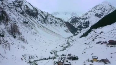 Flight over snow-capped valleys and mountains in winter - aerial footage