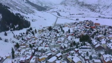 Kışın İsviçre 'nin ünlü Andermatt köyü üzerinde uçuş - hava görüntüleri