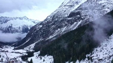 Flight over snow-capped valleys and mountains in winter - aerial footage
