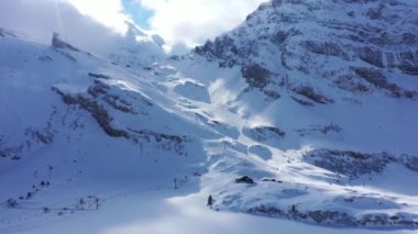 Flight over snow-capped mountains in the Swiss Alps on a winters day - aerial footage